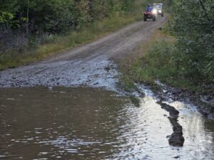 ATV splashing through a muddy trail on a New Brunswick ATV adventure